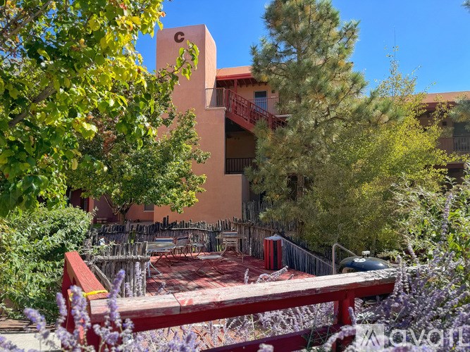 A building with a balcony and a tree in front of it.