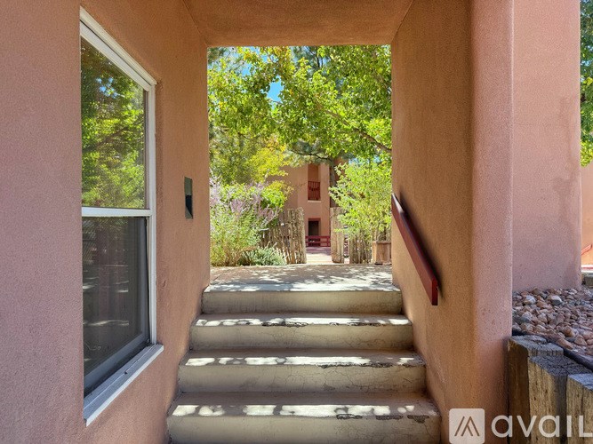 A staircase leads to a house with a garden in the background.