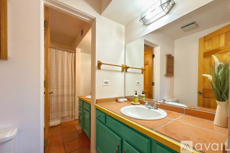 A bathroom with green cabinets and a white sink.