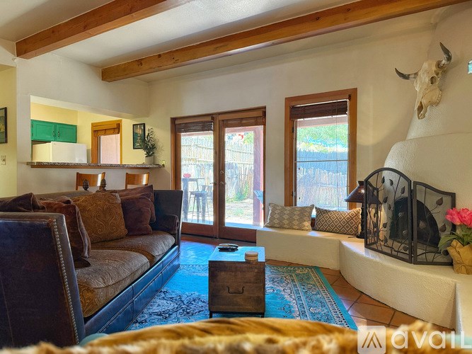 A living room with a brown couch and a cow skull on the wall.