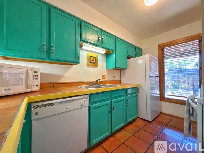 A kitchen with green cabinets and a white fridge.