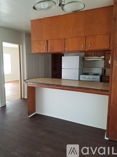 A kitchen with wooden cabinets and a white fridge.