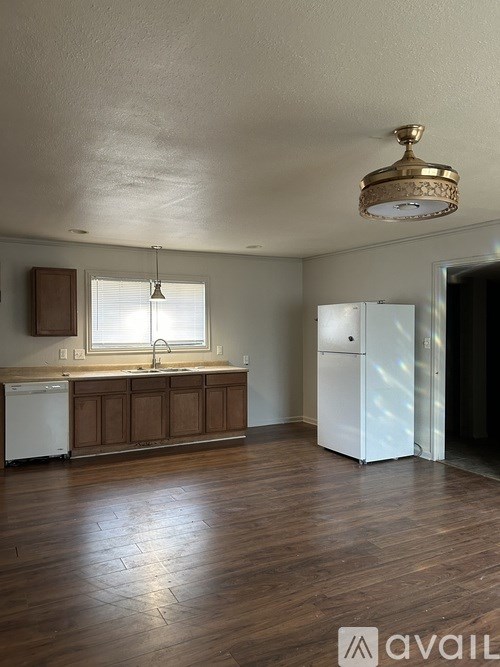 A kitchen with wooden floors and white appliances.