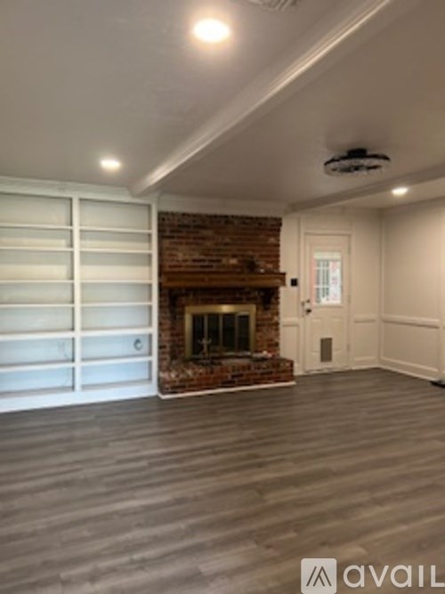 A room with a fireplace and a fan on the ceiling.