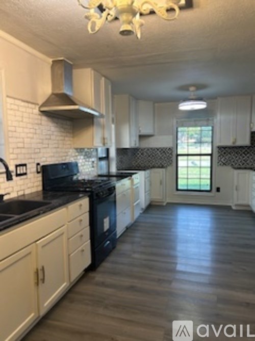 A kitchen with black countertops and white cabinets.