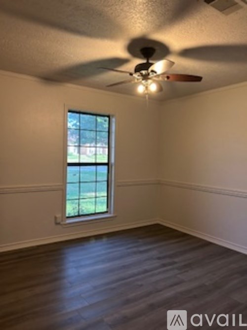 A room with a ceiling fan and a window.