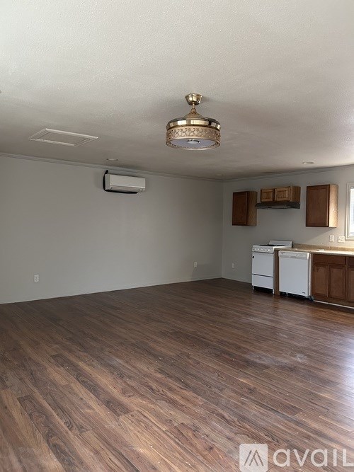 A room with wooden flooring and a chandelier.