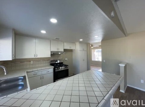 A kitchen with white cabinets and a tiled floor.