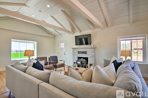 A living room with a large grey sofa and a fireplace.