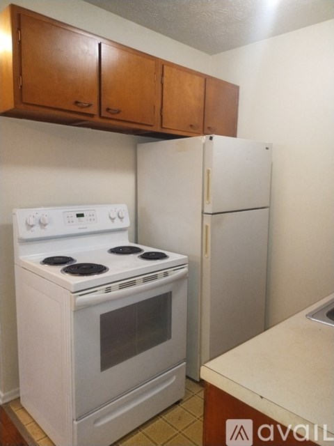 A white stove and refrigerator in a kitchen.