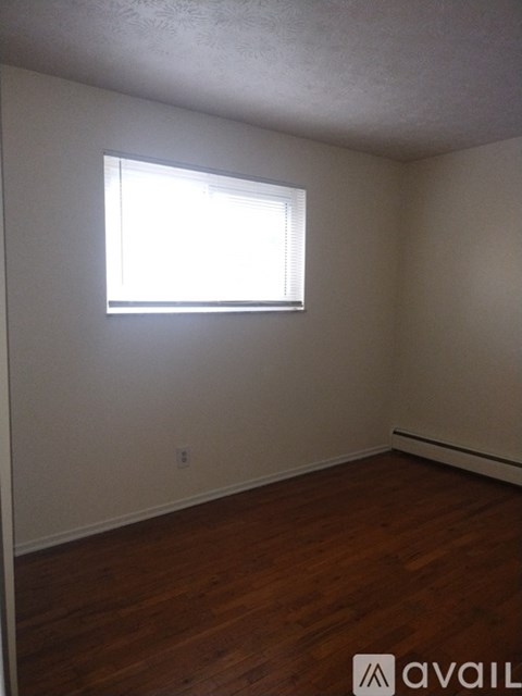 A room with a window and wooden floors.