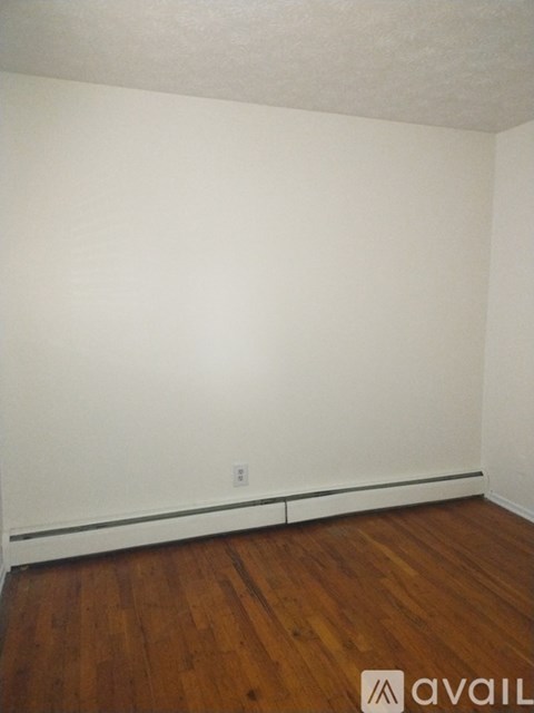 A room with wooden flooring and white walls.