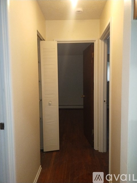 A hallway with a door on the right and a wall on the left.