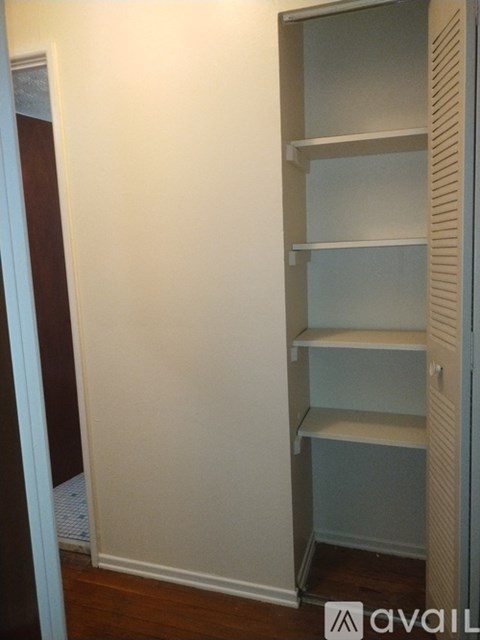 A white wall with a shelf on it.