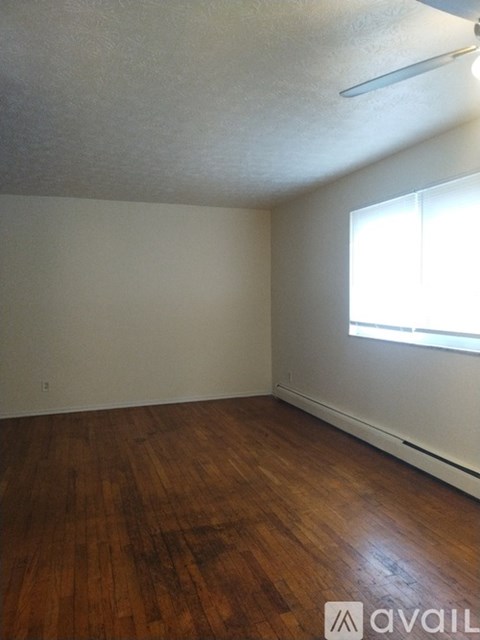 A room with wooden floors and a window letting in light.