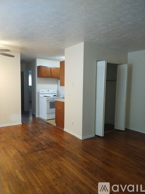 A kitchen with white appliances and wooden floors.