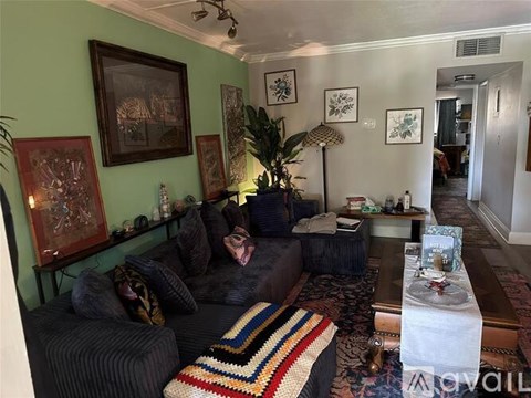 A living room with a grey couch and a striped rug.
