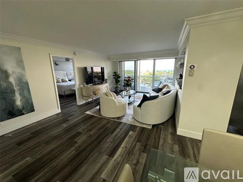 A living room with a large painting on the wall and a view of the backyard through the sliding glass doors.