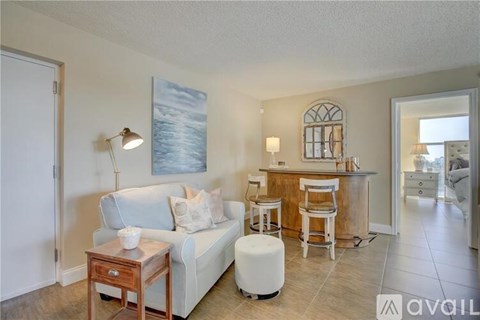 A living room with a couch, a table, and a painting on the wall.