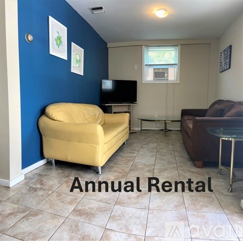 A living room with a yellow couch and a blue wall.