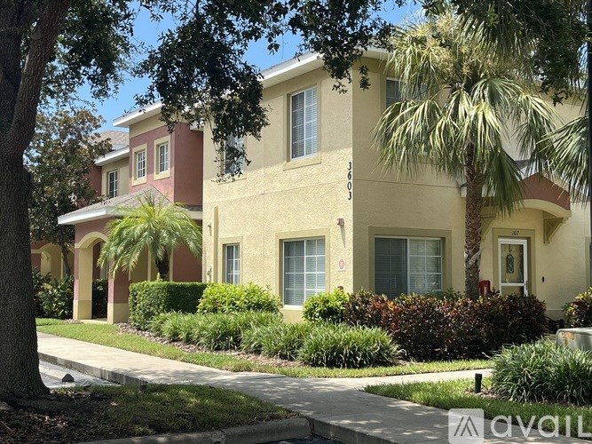 A building with a red awning and a palm tree in front.