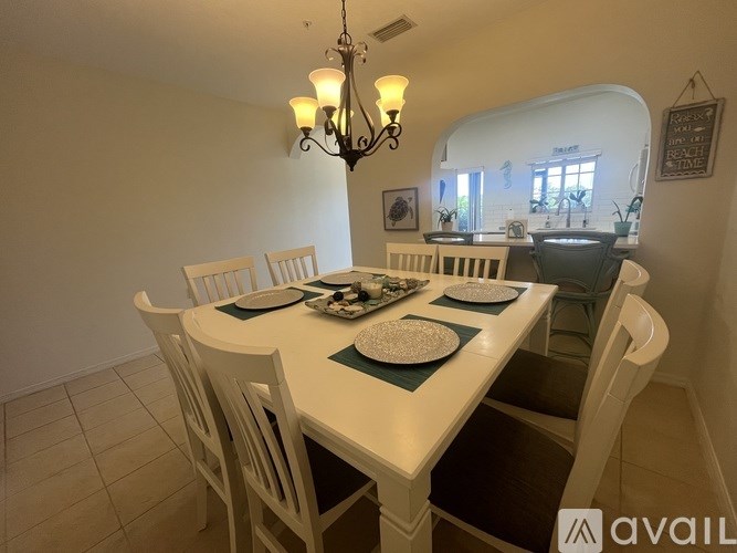 A dining room with a white table and chairs.