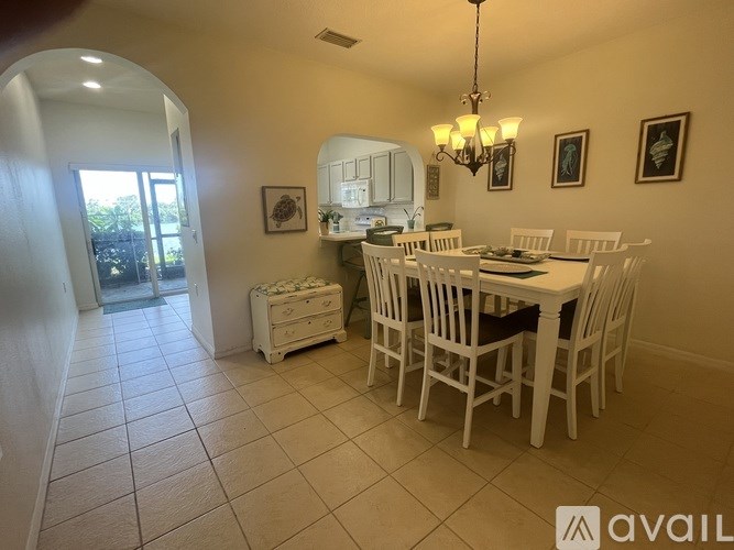A dining room with a white table and chairs.
