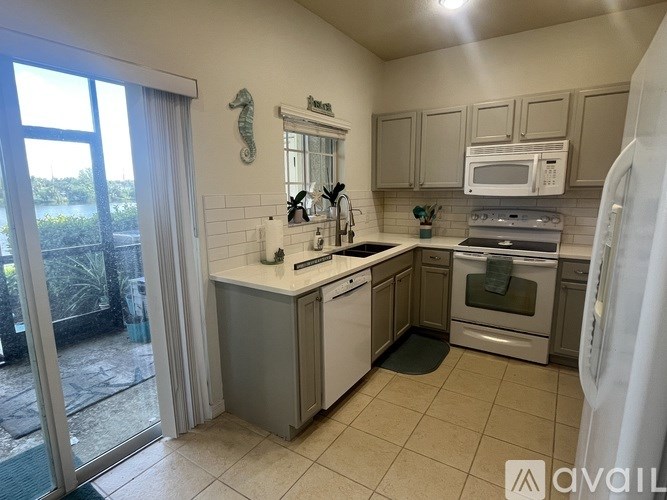 A kitchen with a white fridge, microwave, and stove top oven.