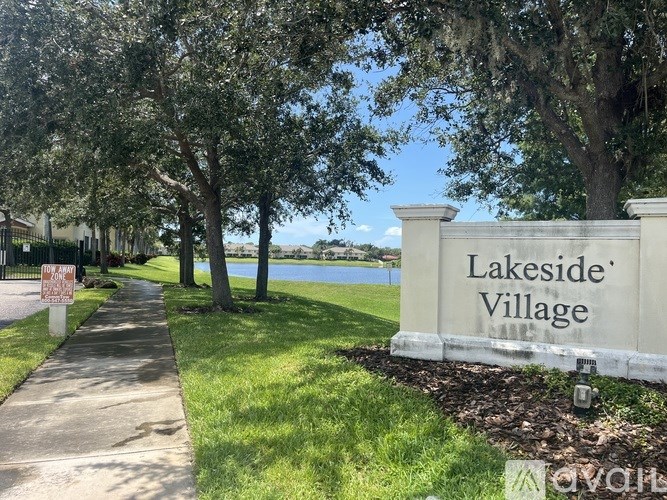 A sign that says Lakeside Village is in front of a body of water.