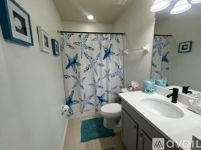 A bathroom with a blue and white shower curtain.