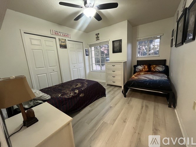 A bedroom with a bed, dresser, and a ceiling fan.