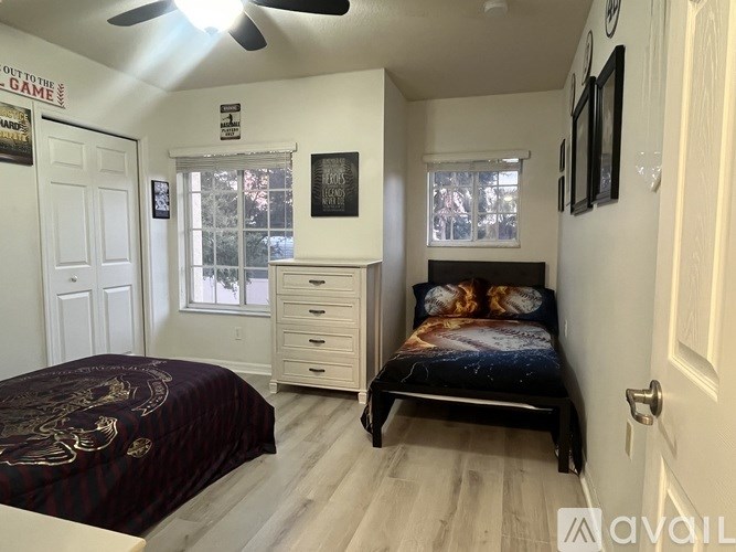 A bedroom with a bed, dresser, and window.