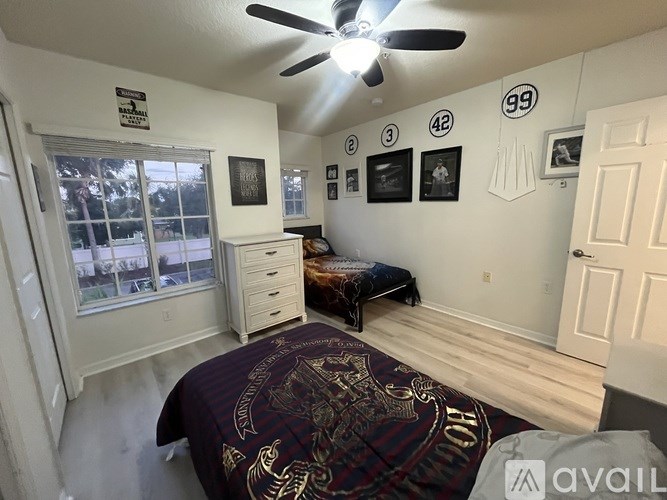 A bedroom with a bed, dresser, and ceiling fan.