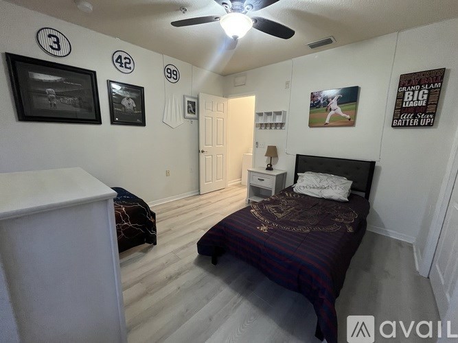 A bedroom with a bed, a dresser, and a ceiling fan.