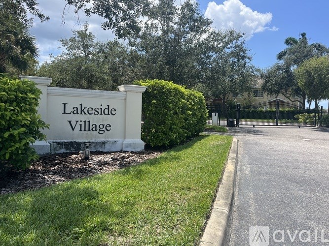 A sign that says Lakeside Village stands in front of a road.