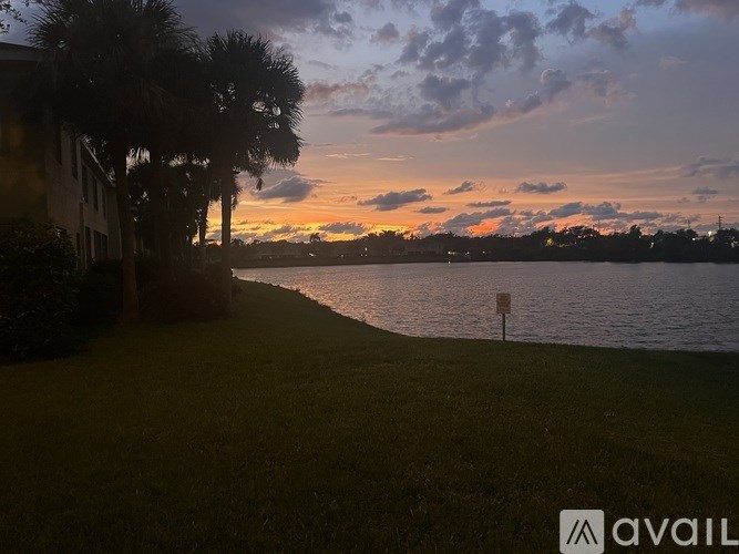 A sunset view with a body of water and a sign in the foreground.