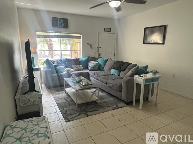 A living room with a grey couch and a white coffee table.