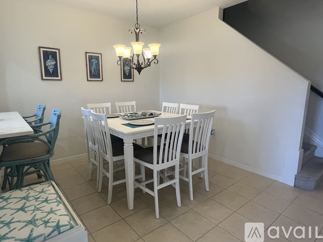 A dining room with a white table and chairs.