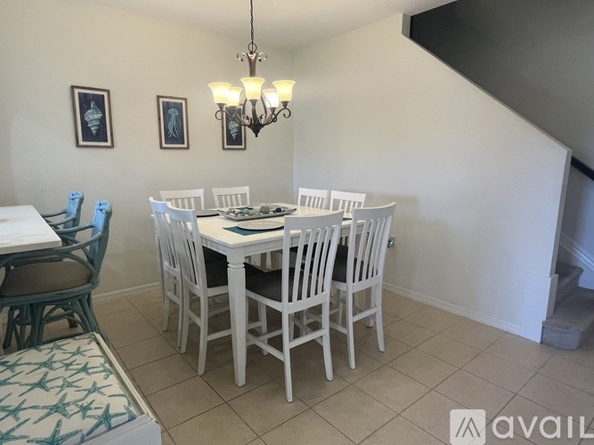 A dining room with a white table and chairs.