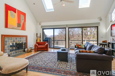 A living room with a fireplace and a painting on the wall.