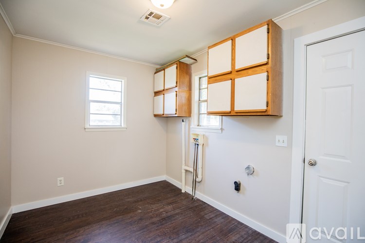 A room with a white door, a window, and a wooden cabinet.