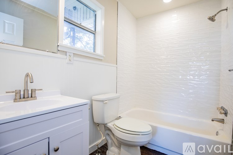 A white toilet sits next to a bathtub in a bathroom.