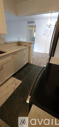 A kitchen with white cabinets and a black countertop.