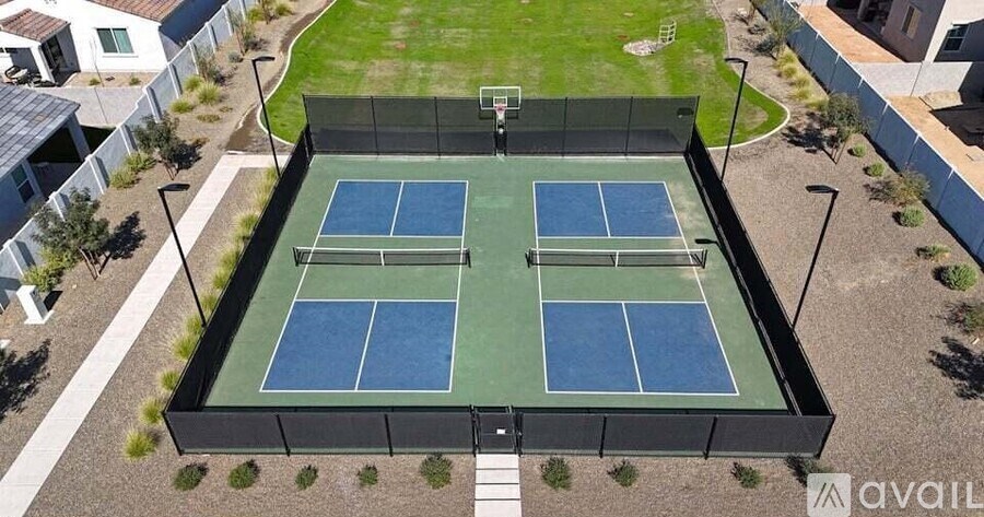 A tennis court surrounded by a black fence.