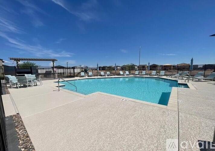 A large outdoor swimming pool surrounded by a fence.