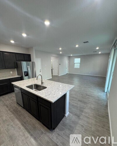 A kitchen with a sink and a refrigerator.