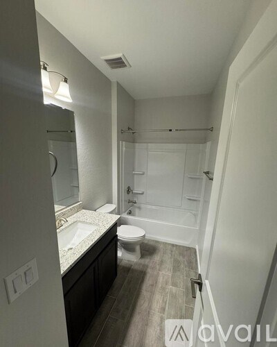 A bathroom with a toilet, sink, and bathtub.