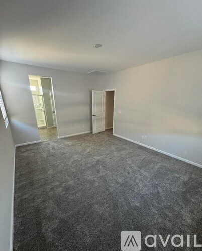 A room with grey carpet and white walls is available for rent.