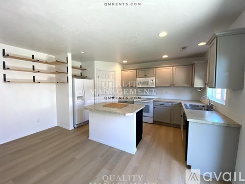 A kitchen with a white countertop and cabinets, and a dining area with a table and chairs.