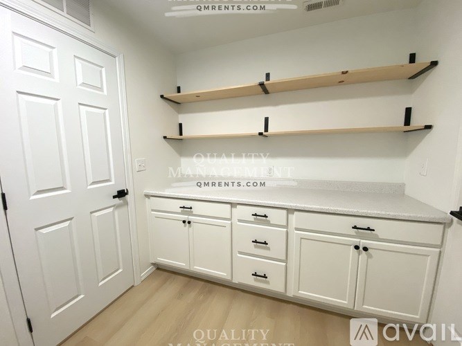 A white pantry with shelves and cabinets.